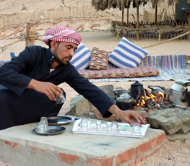 Beduin v majhnem zaselku v puščavi pripravlja tradicionalni beduinski čaj. Foto: Urban Modic