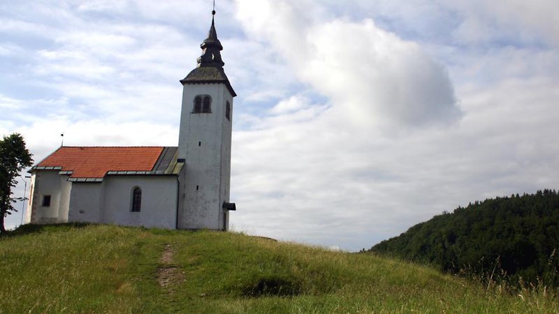 Fotografija: Križna goraŠe na Križno goro. Če se iz Škofje Loke odpravimo proti Kranju, v vasi Dorfarje zavijemo levo proti Crngrobu in pod cerkvijo parkiramo. Tisti, ki teže hodite, se zapeljite prav do cerkve. Na levi ob poti boste opazili dvoje, lep kozolček, pokrit s slamo, in malo za njim čudovit čebelnjak s toliko panjskimi končnicami, da jim ni konca. Cerkev, ki je tu od 13. stoletja, je posvečena Marijinemu oznanjenju. Od tod se zapeljemo po lepi makadamski cesti in sredi gozda se ustavimo ob enem najstarejših kužnih znamenj pri nas, ki mu rečejo tudi rdeče znamenje. Najstarejši podpisi romarjev segajo tja v leta malo po 1500. Nadaljujemo v Staro Loko, lahko skozi Virlog, in na obrobju mesta zavijemo po oznaki desno za Križno goro. Pri gostišču Pri Boštjanu pustimo avto in jo ali peš ali z vozičkom po lepi asfaltni cesti in malo po makadamski mahnemo levo skozi vas in naprej po grebenu do cerkve sv. Križa.
Špela Žabkar