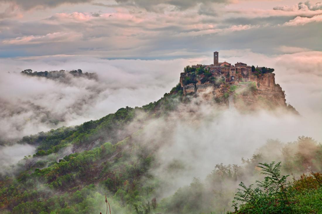 Civita di Bagnoregio v jutranji megli je kot grad v oblakih odrezan od ponorelega sveta. Foto: ermess/Shutterstock