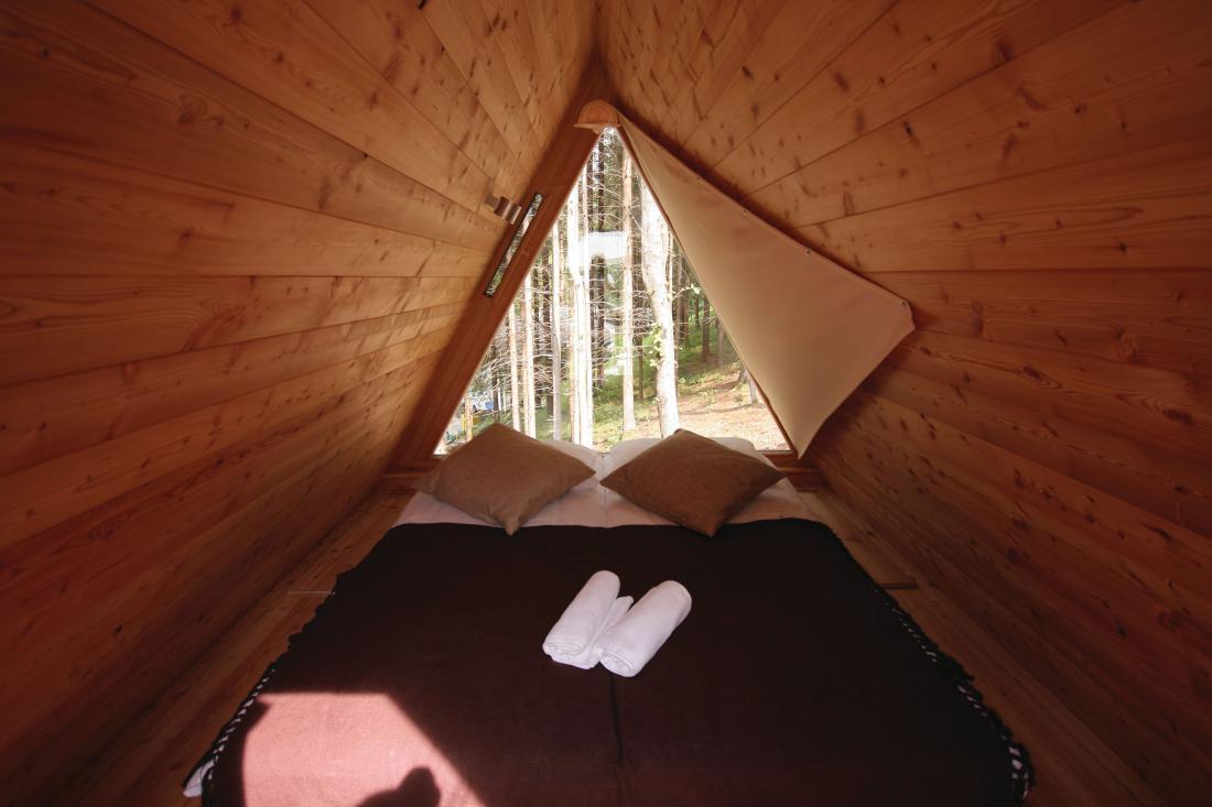 Udobna postelja je narejena iz povsem naravnih materialov. V hišici pa vas v sladek spanec zaziba omamen vonj po lesu.