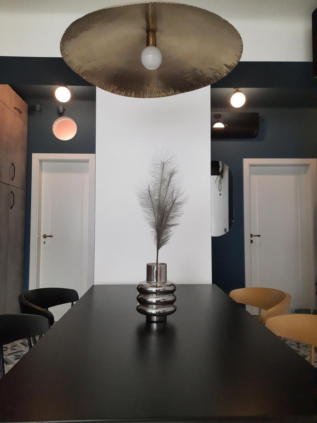 Dva črna in dva rumena stola ter luč nad mizo, ki je eden Manjinih najljubših kosov opreme v stanovanju.