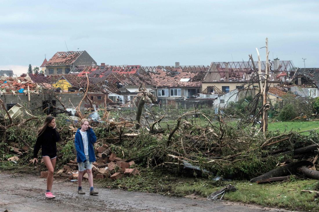 Otroci hodijo mimo uničenih dreves in ruševin hiš v vasi Mikulčice v Južnomoravskem okraju Češke, 60 km južno od Brna, potem ko je predel 25. junija zajel tornado. Umrli so najmanj trije ljudje, številni so utrpeli telesne poškodbe. Foto: Michal Cizek / AFP